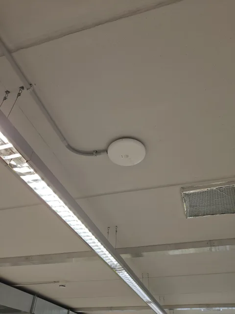 Punto de acceso inalámbrico instalado en el techo de un espacio de trabajo